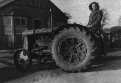 Dorothy Treweeke  on a  tractor outside Hill Crest, Bruern Road (1944)